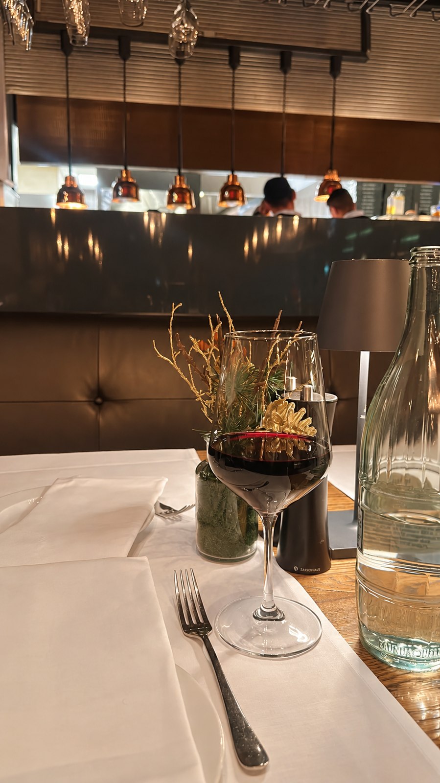 A thoughtfully set restaurant table with flowers and glassware